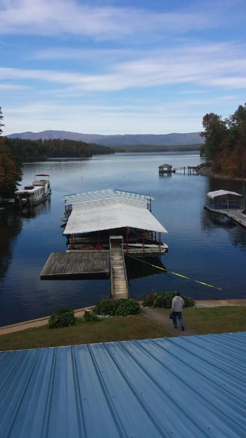 View across a lake from a newly installed blue metal roof in Irving