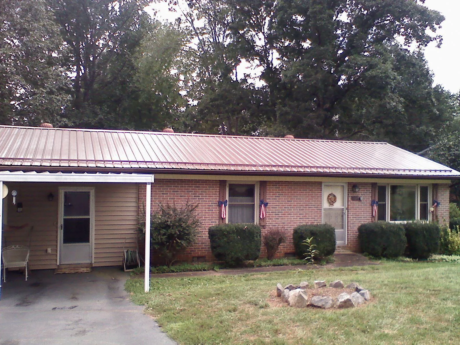 Bronze metal roof and carport on a brick ranch home — Roof Repair work by our crew in Irving